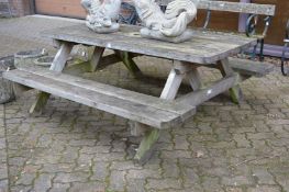 A pine picnic table with bench seats.