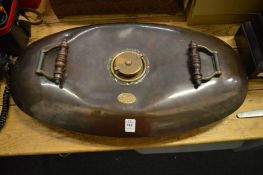 A large copper twin handled warming pan.