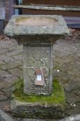 A reconstituted stone bird bath.