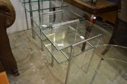 A pair of stylish glass and chrome two-tier lamp/occasional tables.