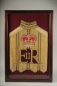AN E. R. ROYAL COACHMAN'S TUNIC in a glass case. 26ins x 16ins.