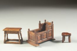 A GOOD 18TH CENTURY DESIGN OAK MINIATURE CRADLE 2.5ins long, JOINT STOOL 1.5ins high. THREE LEGGED
