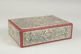 A GOOD REPOUSSE SILVER CASKET, silver top and sides with velvet interior. 9.5ins long, 6.5ins