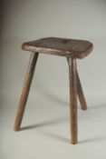 A PRIMITIVE THREE LEGGED CUTLER'S STOOL. 19ins high.