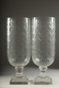 A PAIR OF CUT GLASS HURRICANE LAMPS on square bases. 16ins high.