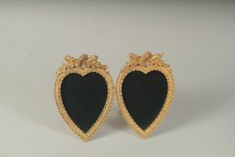 A DOUBLE GILT METAL HEART SHAPED PHOTOGRAPH FRAME.