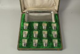 TASSILLY BOIVIN, PARIS. A SET OF TWELVE GLASS VODKA TOTS with silver bases and tray, in a fitted