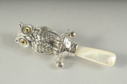 A SILVER AND MOTHER-OF-PEARL OWL RATTLE.