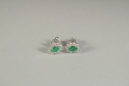 A PAIR OF 18CT WHITE GOLD AND EMERALD EAR STUDS.