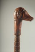 A NAIVE FOLK ART DOG'S HEAD WALKING STICK. 34ins long.
