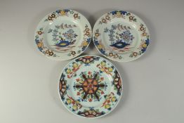 A PAIR OF TIN GLAZE FLORAL PLATES and another similar. 9ins diameter (3).