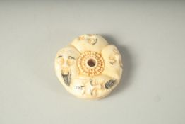 A CARVED BONE FACES NETSUKE. 1.25ins.
