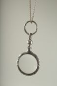 A SILVER SPY GLASS on a chain.
