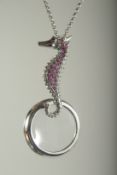 A SILVER RUBY SET SEAHORSE SPYGLASS ON A CHAIN.