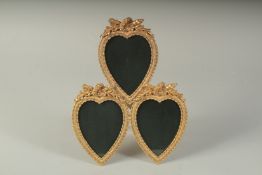 A TRIPLE GILT METAL HEART SHAPED PHOTOGRAPH FRAME.