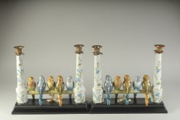 A PAIR OF SEVRES DESIGN PORCELAIN GROUP OF FIVE PARROTS ON A PERCH. 15ins high.