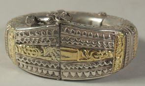AN OMANI MUTTRAH MUSCAT BALOUCH GOLD OVERLAID SILVER BRACELET.