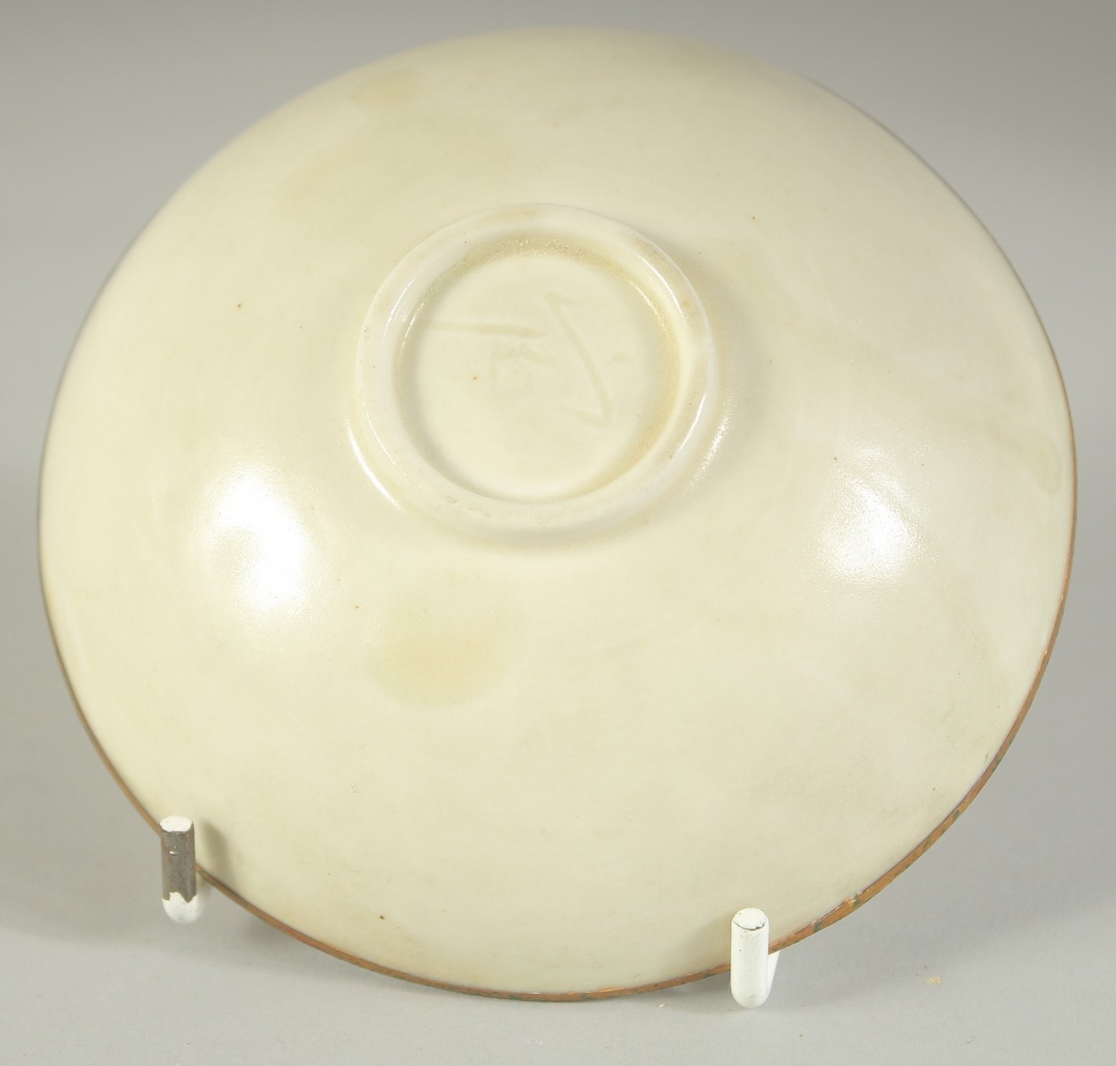 A CHINESE DING STYLE TEA BOWL, with carved floral decoration and gilt rim, 10cm diameter. - Image 2 of 2