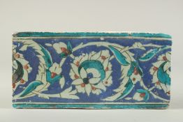 A FINE 16TH CENTURY OTTOMAN TURKISH IZNIK BORDER TILE, 25cm x 12.5cm.