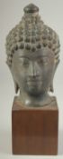 A FINE 19TH CENTURY OR EARLIER THAI BRONZE BUDDHA HEAD, elevated on a wooden base, head 19cm high.