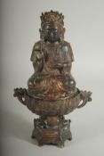 A CHINESE BRONZE SEATED DEITY LIDDED CENSER, the censer of lotus form, with traces of gilt