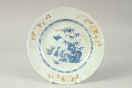 A 19TH CENTURY CHINESE GILT DECORATED BLUE AND WHITE PORCELAIN PLATE, with enamel painted flowers