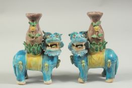 A PAIR OF SANCAI GLAZED POTTERY LION CANDLESTICKS, 16cm high.
