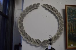 A pair of painted metal laurel wreath wall hangings.