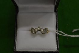 A yellow metal ring with nine baguette cut diamonds.