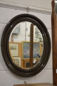 An oval wall mirror.