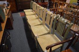 A set of six rush seated and painted dining chairs, four cream and two green.