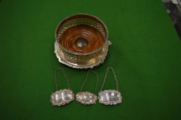 Silver decanter labels, two whiskey and one cognac together with a plated decanter stand.