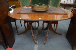 A 19th century mahogany twin pillar dining table with two leaves.