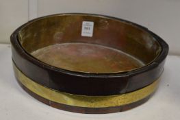 A brass bound mahogany oval shaped small jardiniere with brass liner.