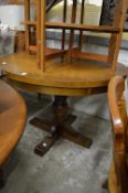 A circular oak extending pedestal dining table.
