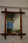 A small faux bamboo framed mirror.
