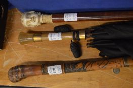 A Chinese bamboo fishing rod walking stick together with another stick and a parasol.