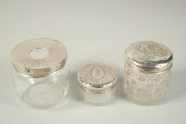 A GLASS AND SILVER RING TIDY, Birmingham 1907, and two silver top bottles, 1904 (3).
