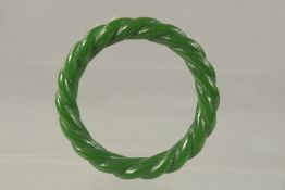 A GREEN JADE TWIST BANGLE. 8cms.