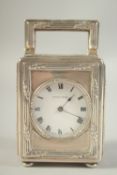 A MAPPIN AND WEBB SILVER CASED MINIATURE CLOCK. No. 55287 with carrying handle, on four bun feet.