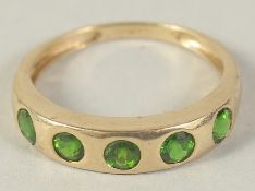 A 9CT GOLD FIVE STONE GREEN GARNET RING