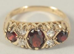 A 9CT GOLD GARNET THREE STONE AND CUBIC ZIRCONIA RING