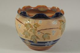 A DOULTON LAMBETH SLATERS PATENT STONEWARE CIRCULAR JARDINIERE with blue rim and leaf decoration.