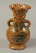 A TWO-HANDLED STONEWARE VASE with sun gods. 9.5ins high.