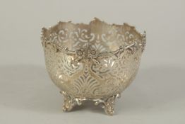 A VICTORIAN SILVER PIERCED CIRCULAR BOWL with floral borders,scrolls, on four curving feet. 5ins