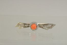 A GOLD DIAMOND AND CARVED CORAL BAR BROOCH.