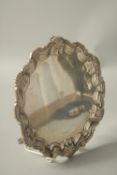 A VICTORIAN SILVER PIE CRUST SALVER with shell borders on three curving feet, 8ins diametrer. London