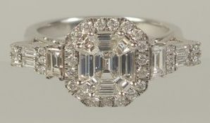 A SUPERB EMERALD CUT DIAMOND CLUSTER RING set in .750 white gold.
