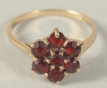 A 9CT GOLD GARNET FLOWER CLUSTER RING