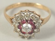 A 9CT GOLD RUBY AND CUBIC ZIRCONIA CLUSTER RING